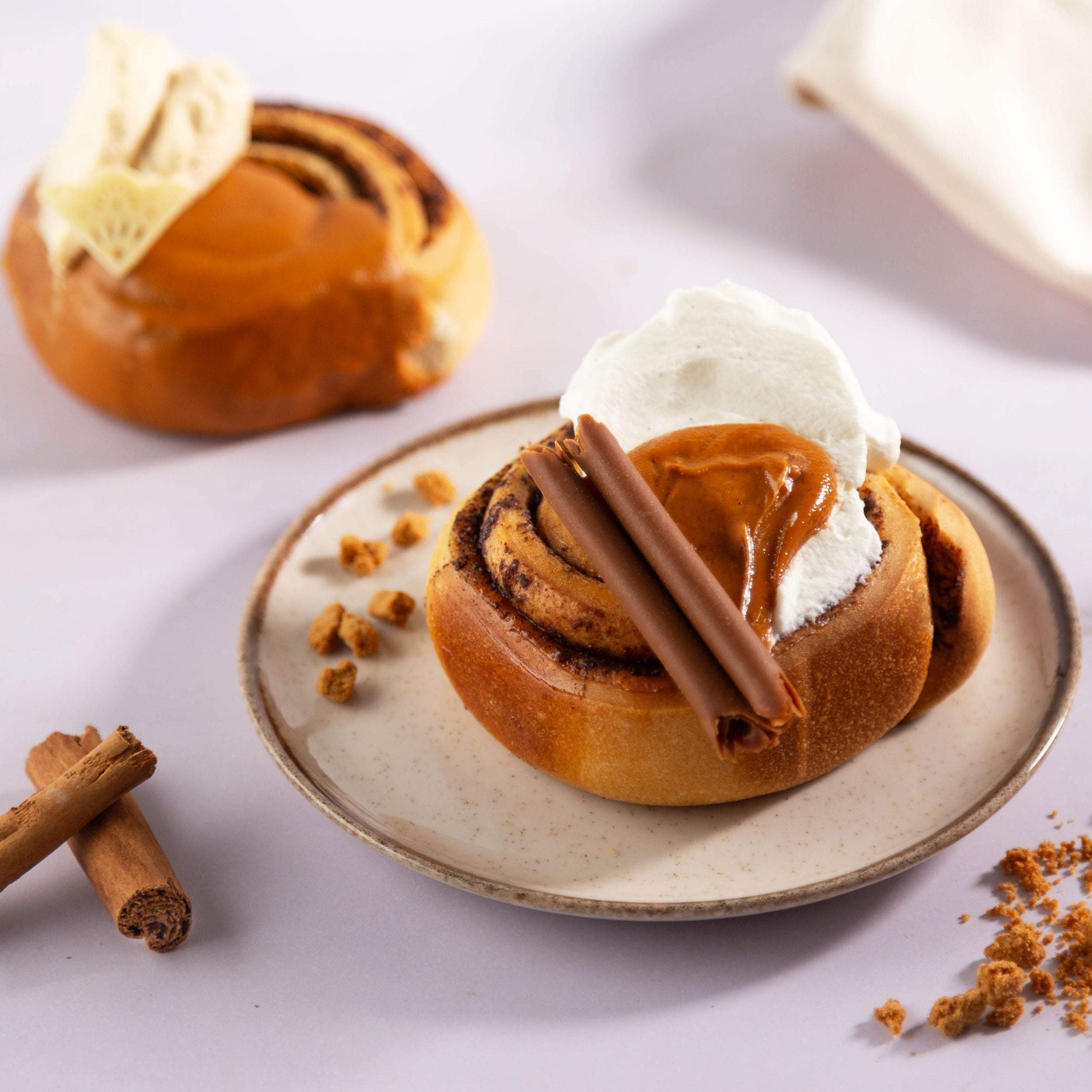 Cinnamon roll con crema cinnamon e panna montata con decorazioni alla canella 